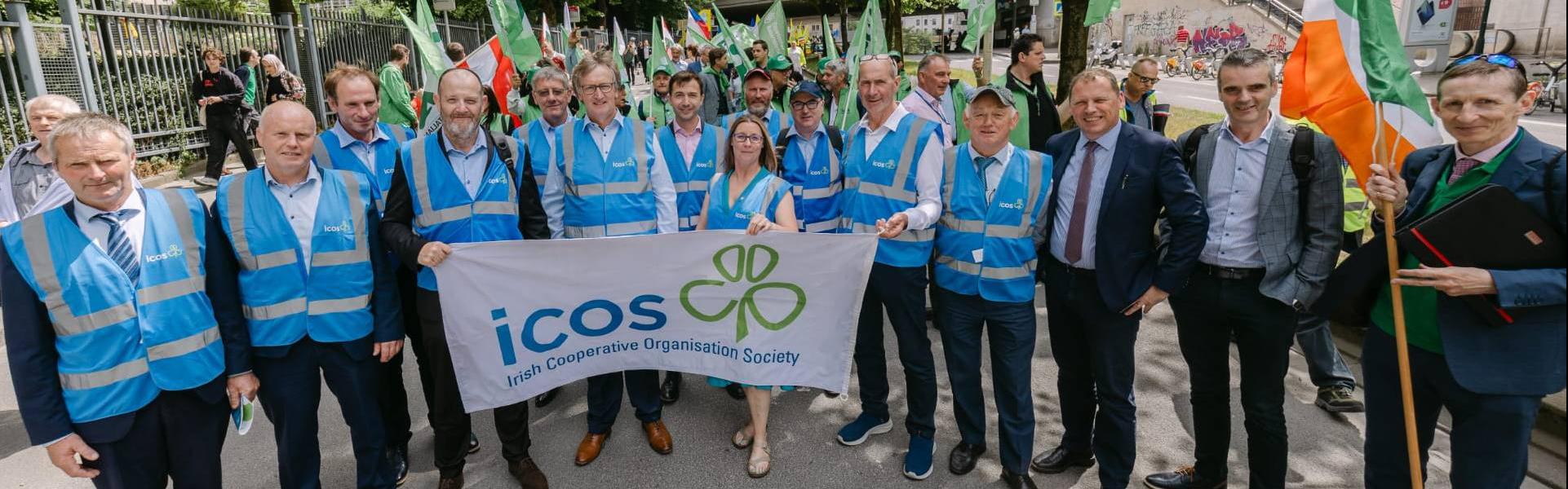 group of people holding an icos flag